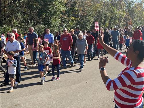 vets marching with students and faculty waving from sides